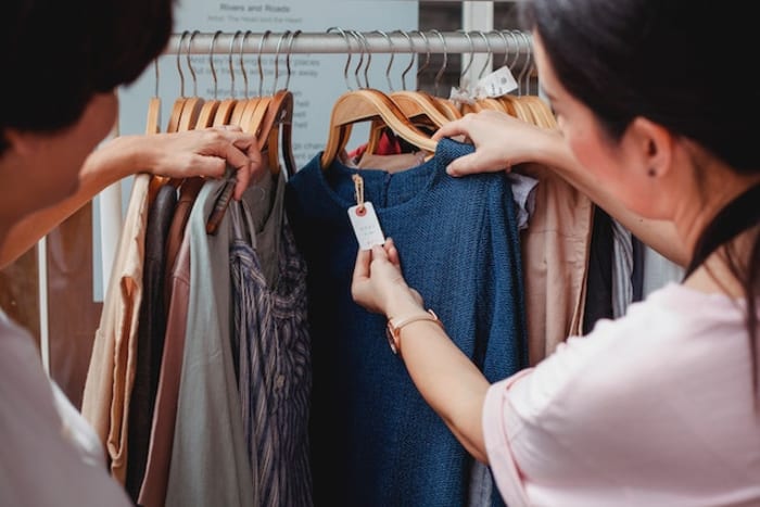two girls checking price of a sweater